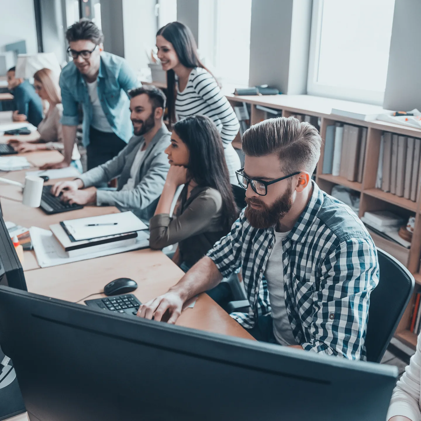 A collaborative technical team working at computers.