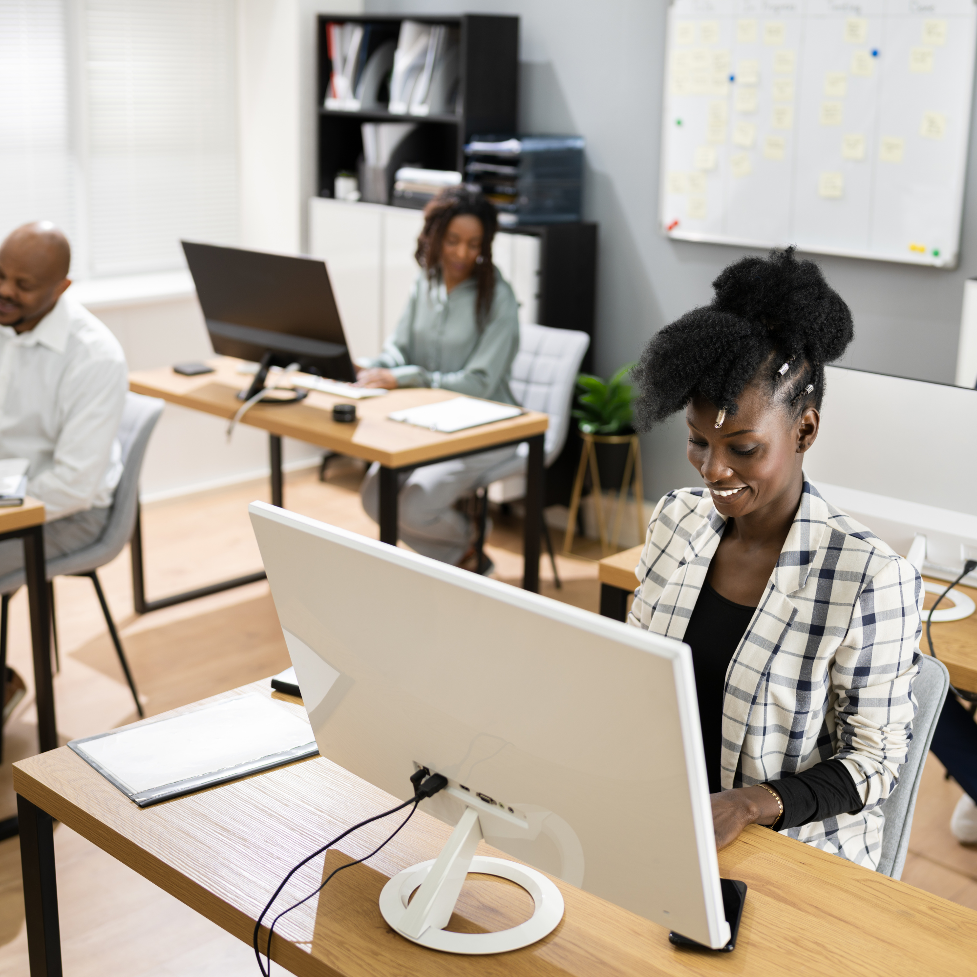 Colleagues working at computers in a shared office.